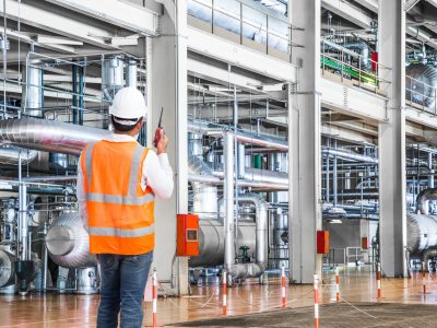 Engineer working in a thermal power plant with talking on the walkie-talkie for controlling work